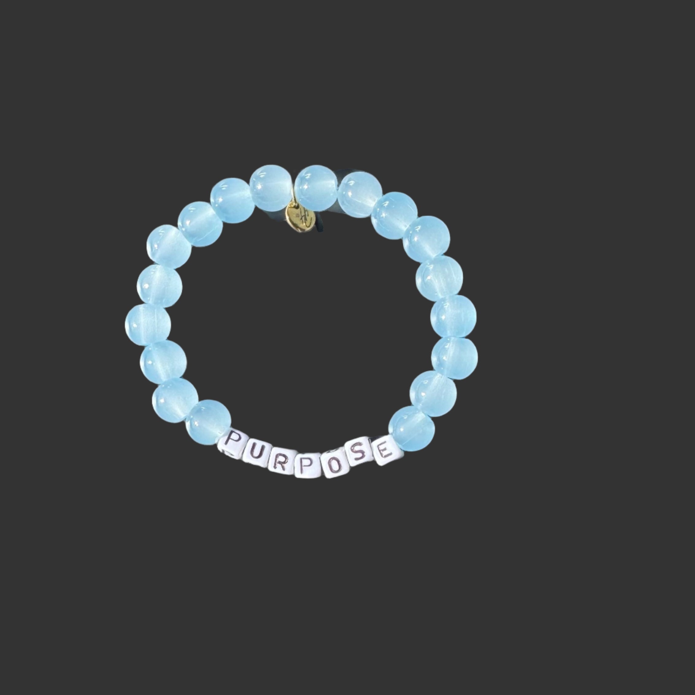 Blue beaded bracelet with 'PURPOSE' charm on a black background