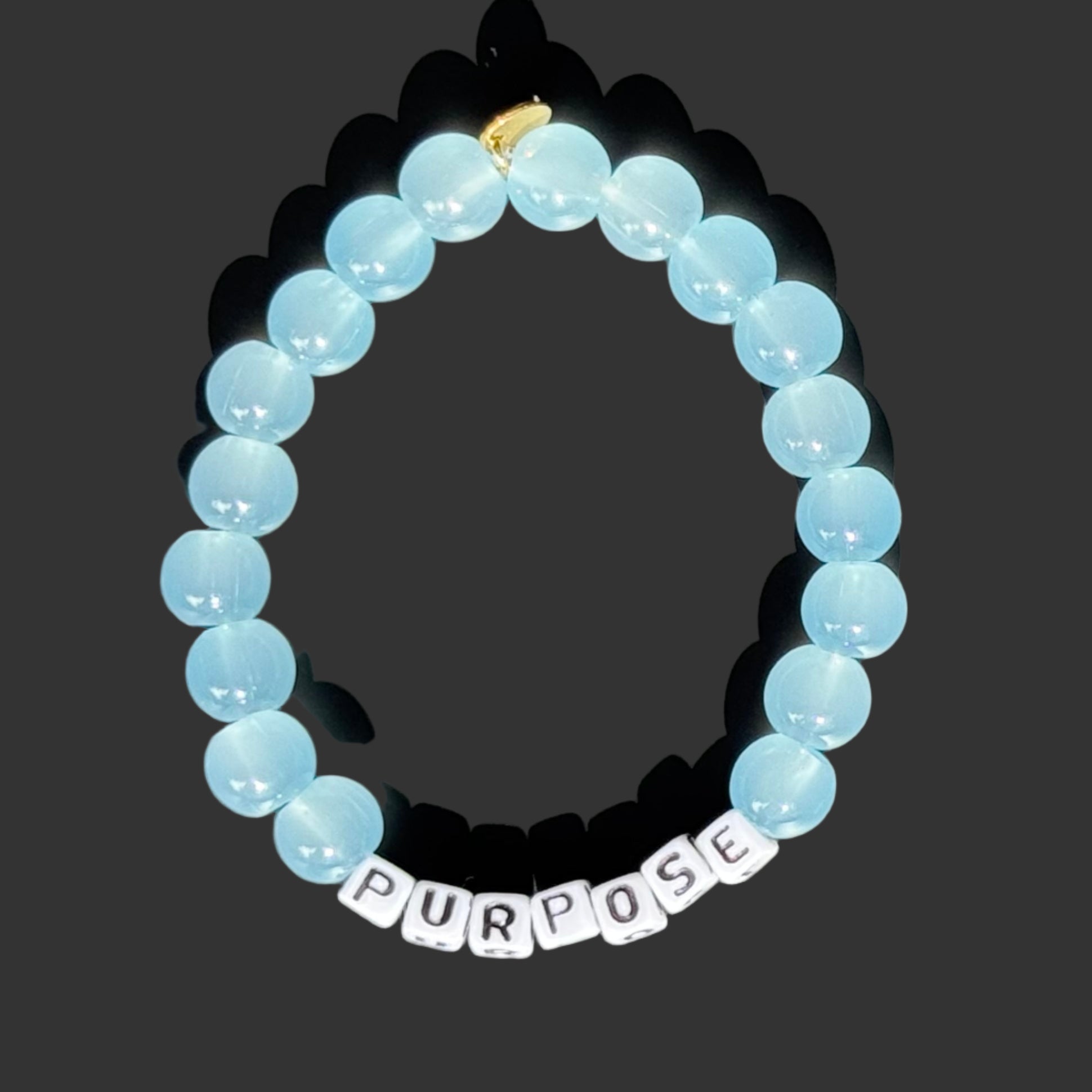 Bracelet with blue beads and a word charm on a gray background